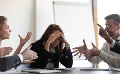 Frustrated,Millennial,Female,Worker,Sitting,At,Table,With,Colleagues,,Felling